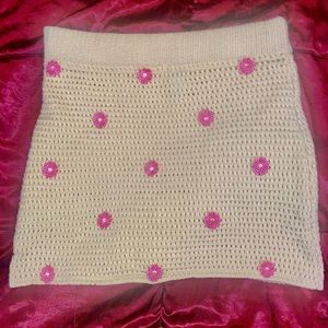 Yellow crochet skirt with pink embroidered flowers.